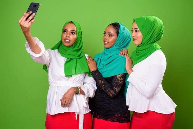 Young African Muslim woman against chroma key with green wall