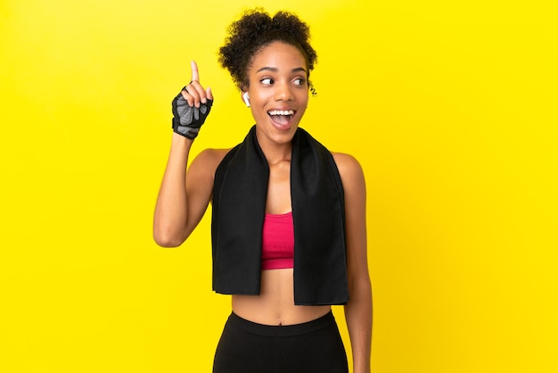 Young african sport woman isolated on yellow background intending to realizes the solution while lifting a finger up