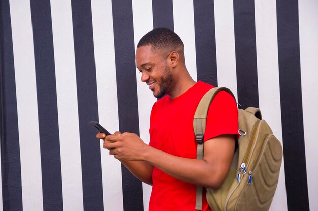 Young african student feeling excited as he operates his cellphone