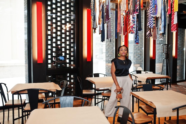 Young african woman in black blouse at cafe.