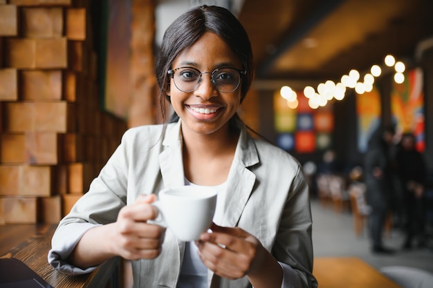 Young african woman at cafe drinking coffee