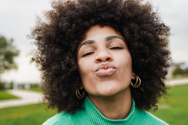 カメラでキス口をしている若いアフリカの女性