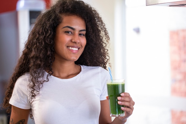 La giovane donna africana gode del frullato vegetariano sano per perdita di peso e disintossicazione