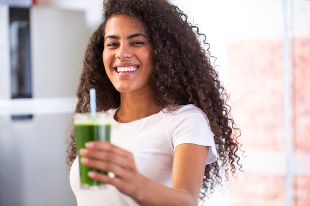 Young african woman enjoy healthy vegetarian smoothie for weight loss and detox  