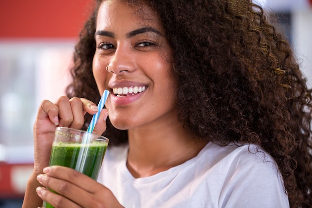 Young african woman enjoy healthy vegetarian smoothie for weight loss and detox  