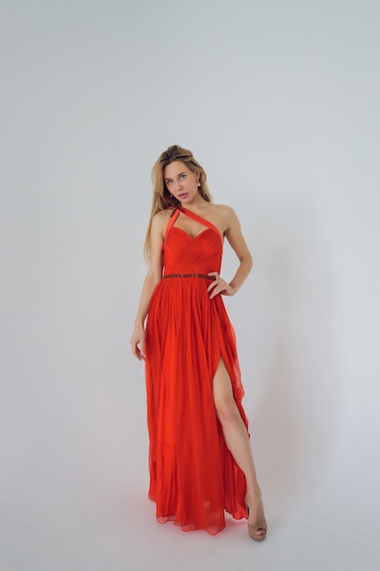 Young african woman in long red dress isolated on gray background