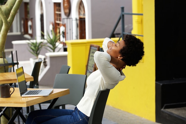 Молодая африканская женщина, расслабляющий на открытом кафе