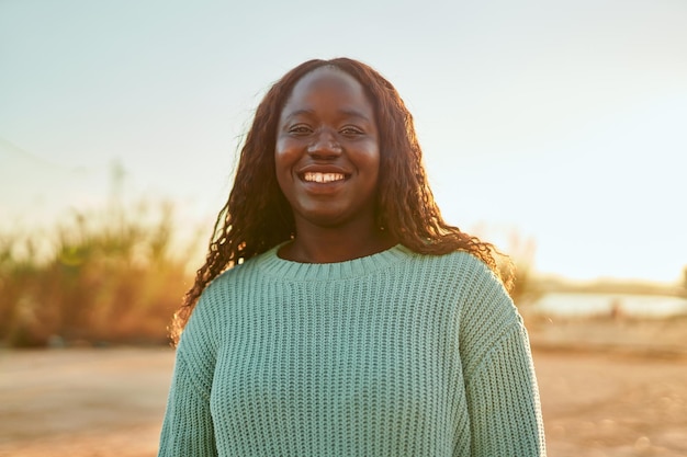 Молодая африканка счастливо улыбается в парке