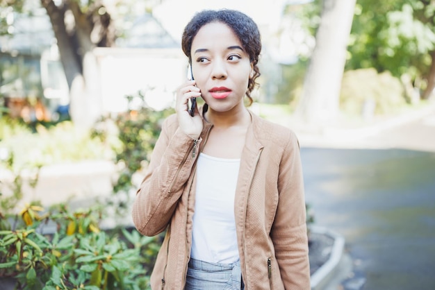 Young African woman speaking on mobile phone