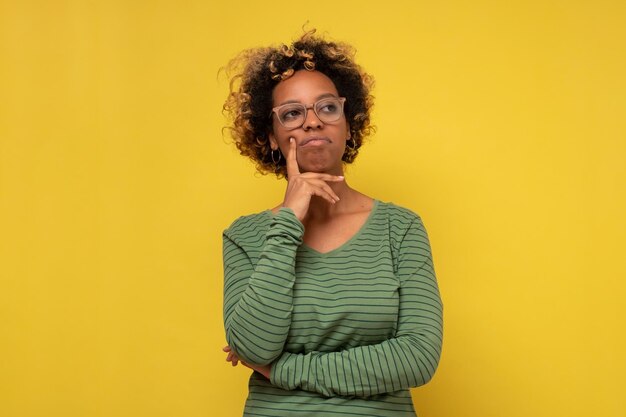 Young african woman thinking with hand on chin trying to makw a decision