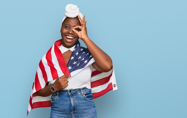 アメリカ合衆国の旗を保持しているターバンを持つ若いアフリカの女性