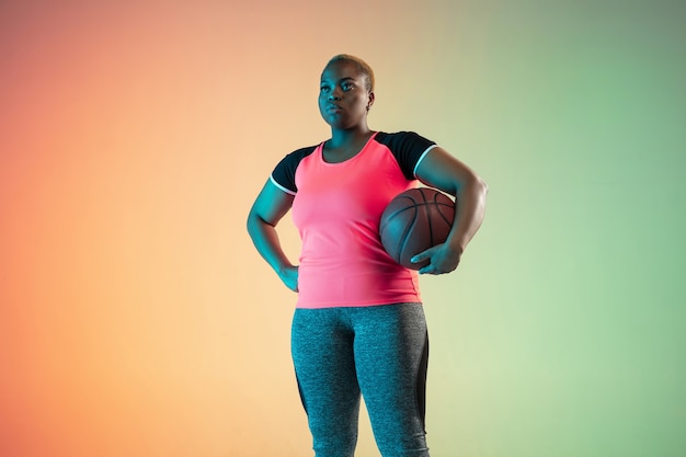 Young africanamerican plus size female models training on gradient wall