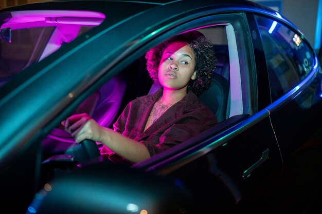 Young africanamerican woman driving electric car