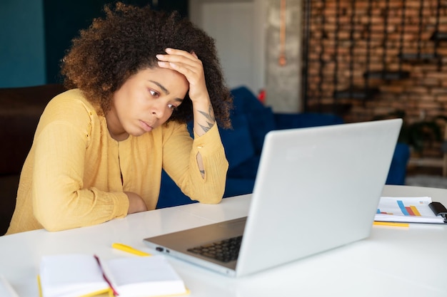 young africanamerican woman using laptop at home