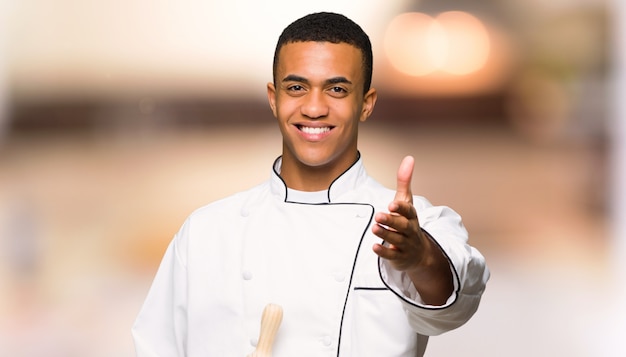 Young afro american chef man shaking hands 