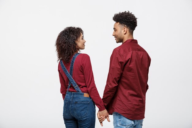 Young afro american couple holding hands isolated on white background