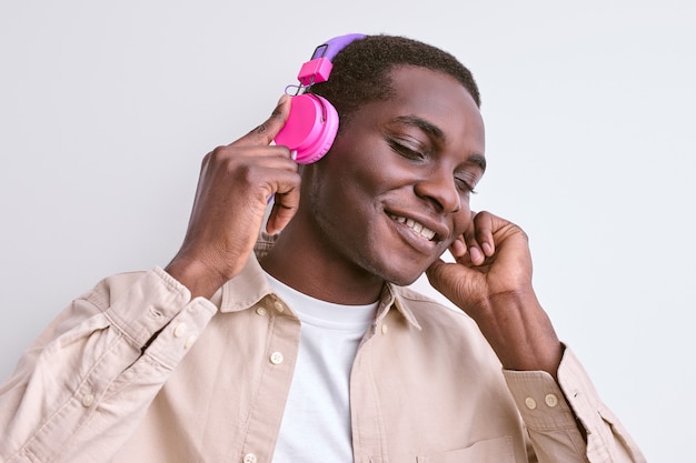 젊은 아프리카 계 미국인 남자는 헤드폰으로 음악을 듣고 즐긴다.