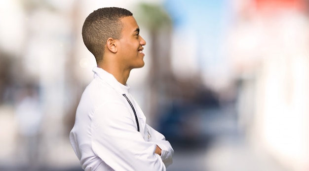 Young afro american man doctor in lateral position at outdoors