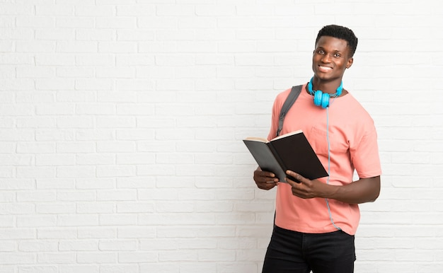 若いアフロアメリカ人男子学生が本を読む