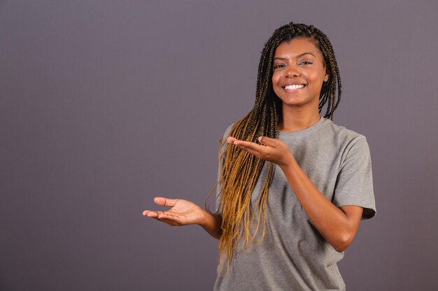 Young afro brazilian woman presenting something with his hands to the left Photo for ad Advertising