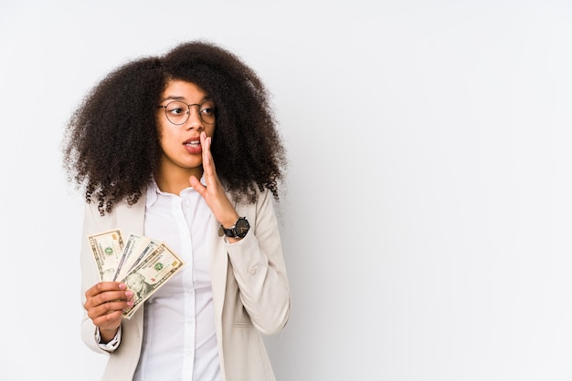 Young afro business woman holding a credit car isolated Young afro business woman holding a credit caris saying a secret hot braking news and looking aside