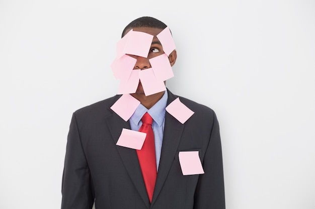 Young Afro businessman covered in blank notes