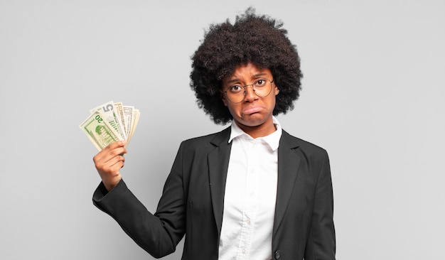 Young afro businesswoman feeling sad and whiney with an unhappy look, crying with a negative and frustrated attitude. business concept