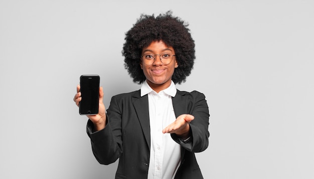 Young afro businesswoman smiling happily with friendly, confident, positive look