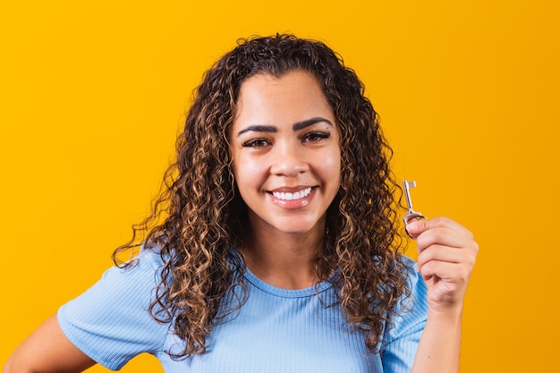 Young afro girl holding a house key.