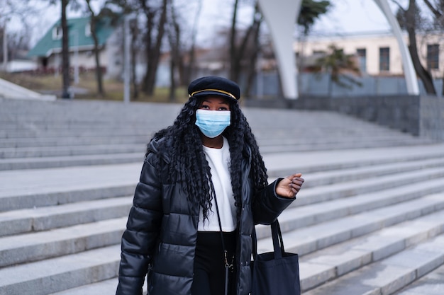 안면 마스크를 사용하여 야외 아프리카 소녀에 얼굴 의료 마스크와 젊은 아프리카 소녀