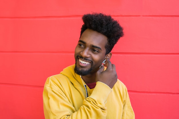 Young afro man listening to music with earphones