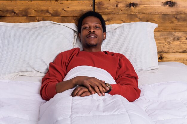 Photo young afro man relaxing on bed at home.