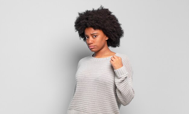 young afro woman against isolated wall