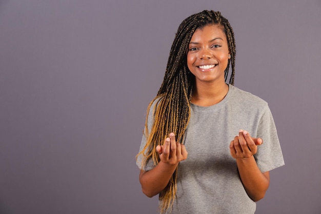 Giovane donna afro brasiliana che fa cenno con le sue mani vieni qui benvenuto