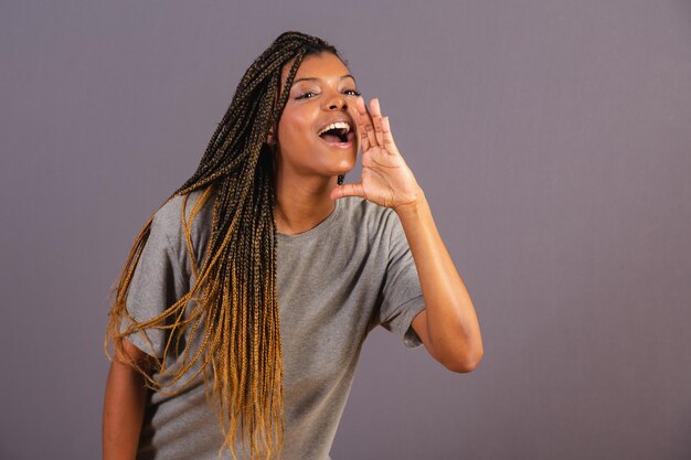 Young afro woman brazilian shouting with hands promotion announcing discount called