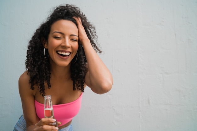 ビールを飲む若いアフロ女性