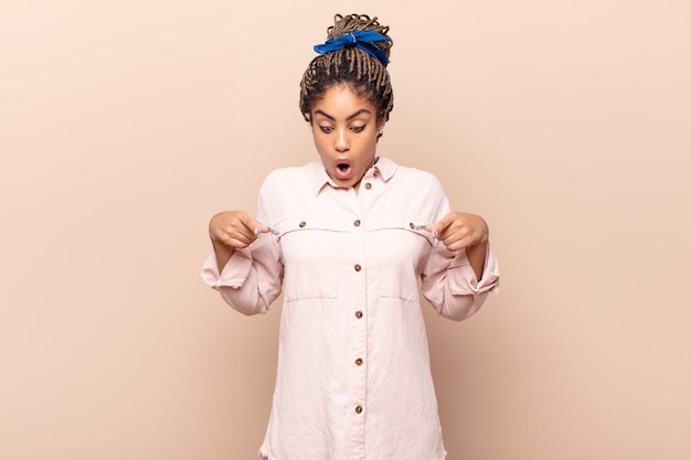 Young afro woman feeling shocked, open-mouthed and amazed