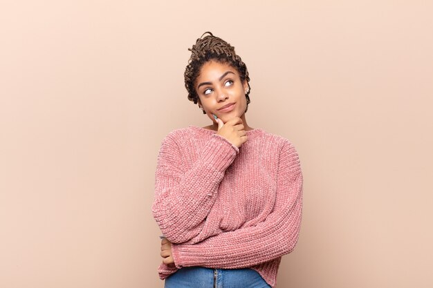 Photo young afro woman feeling thoughtful, wondering or imagining ideas isolated