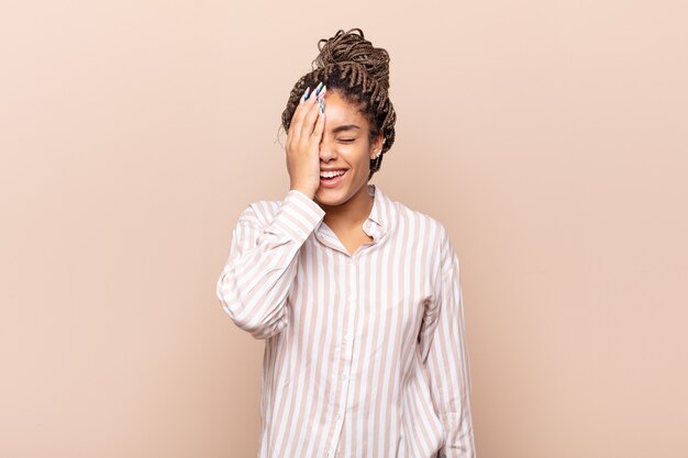 Photo young afro woman laughing and slapping forehead like saying dãâãâ¢ãâãâãâãâãâãâãâãâãâãâãâãâ´oh! i forgot or that was a stupid mistake