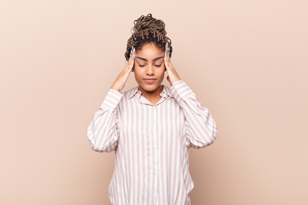 Young afro woman looking concentrated, thoughtful and inspired