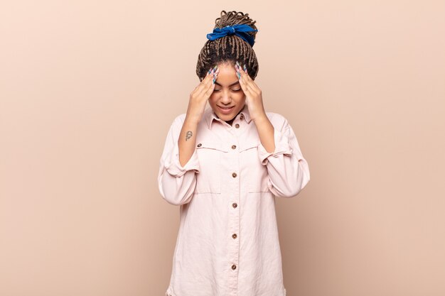 Photo young afro woman looking stressed and frustrated, working under pressure with a headache and troubled with problems