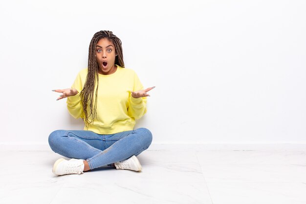 Young afro woman open-mouthed and amazed isolated