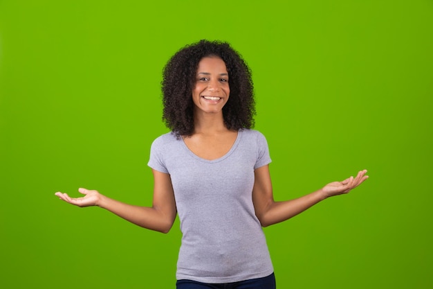 Young afro woman points sideways free for text