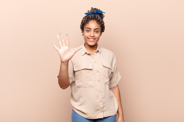 Young afro woman smiling and looking friendly