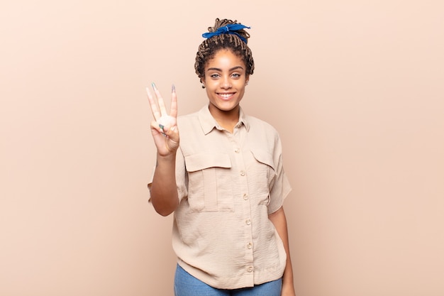 Young afro woman smiling and looking friendly