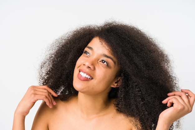 Giovane donna afro che sorride e che osserva in su