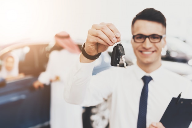 Young Agent in Glasses Hold Car Keys Auto Salon