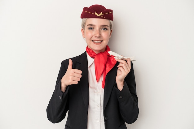 Photo young air hostess caucasian woman holding plane isolated on white background