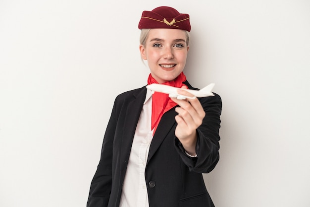 Young air hostess caucasian woman holding plane isolated on white background