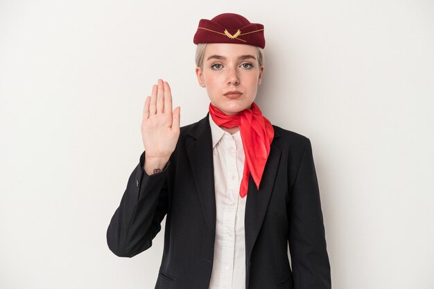 Young air hostess caucasian woman isolated on white background standing with outstretched hand showing stop sign, preventing you.